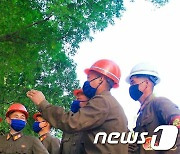 북한 평양 건설장에서 '혁신자들' 알람판 보는 근로자들