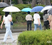 우산으로 비 피하며 길 지나는 시민들