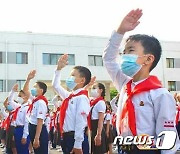 '인공기'에 경례하는 북한 어린이들