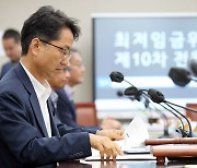 회의자료 보는 박준식 최저임금위원장