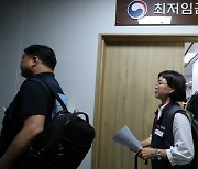 투표 후 퇴장하는 최저임금위 노동계