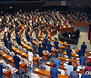 국기에 경례하는 의원들과 국무위원들