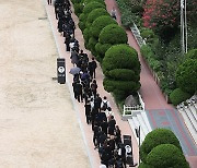 학교 운동장에서 기다리는 추모객들