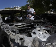 로켓 공격에 파괴된 차량 살펴보는 이스라엘 남성