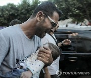 다친 아이 안고 병원으로 향하는 가자지구 남성