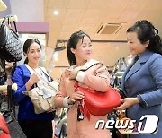 '가을철피복전시회'에서 가방 들어보는 북한 여성