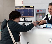 안내데스크에서 여행객 응대하는 이학재 사장