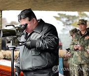 망원경으로 포사격훈련 지켜보는 김정은