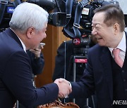 악수하는 성낙인 공동위원장과 김홍일 방송통신위원장