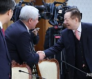 악수하는 성낙인 공동위원장과 김홍일 방송통신위원장