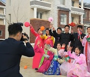 강동온실농장 살림집 받고 기념사진 촬영 중인 북한 주민들