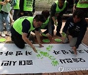 손바닥 인장으로 초록색 리본 만드는 집회 참가자들