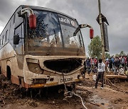 홍수 발생한 케냐의 물에 떠내려 온 파손된 버스