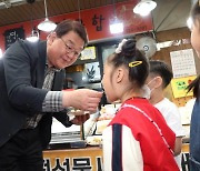[포토] 전통시장서 어린이에게 떡 먹여주는 박성효 소진공이사장