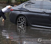 소나기에 침수된 도로, 차량 미는 시민