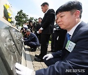 얼굴 부조상 어루만지는 유가족