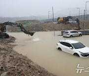 굴착기로 물 퍼내는 침수된 공사 현장