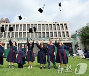 학사모 던지며 졸업 자축하는 유학생들