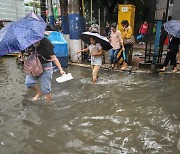 [포토] 태풍 '야기'…물에 잠긴 도시 건너는 사람들