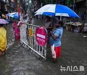 폭우 속 배수구로 거리 물 빼는 시 노동자들