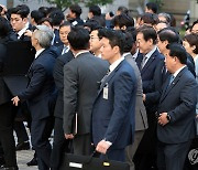 의원과 경찰에 둘러싸인 채 법정 출석하는 이재명