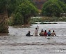홍수로 물에 잠긴 도로 건너는 말라위 주민들